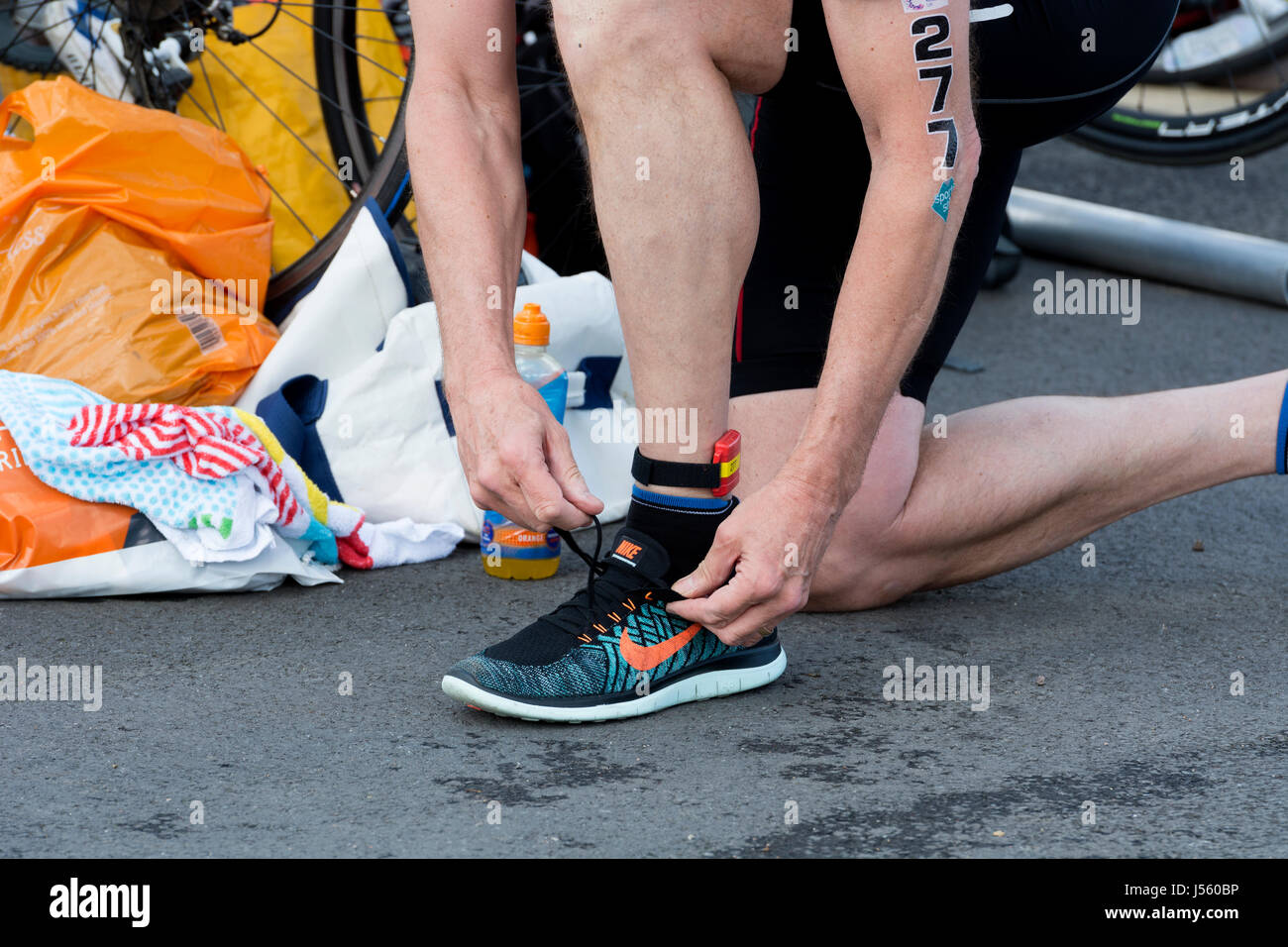 Male competitor putting on Nike running shoes, transition area, Stratford  Triathlon, UK Stock Photo - Alamy