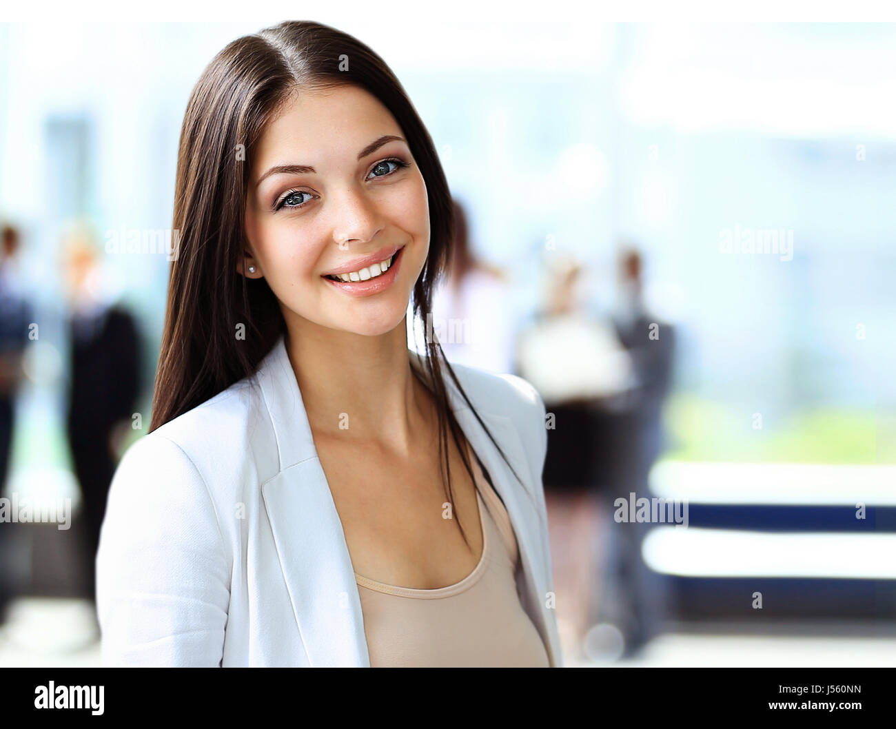 Portrait of a cute young business woman smiling, in an office ...