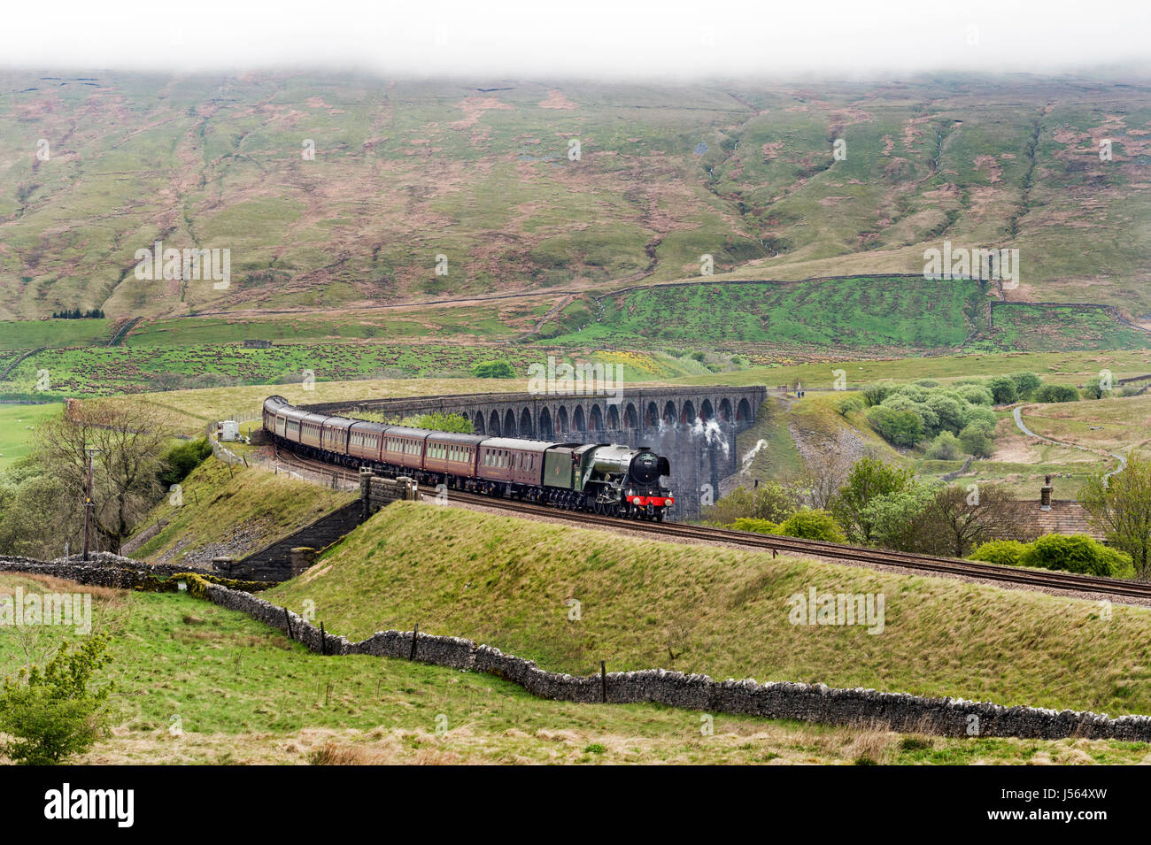 Ribblehead, Yorkshire, UK. 16th May, 2017. The Flying Scotsman crosses the Ribblehead viaduct in the Yorkshire Dales National Park; with the 'Cathedrals Express', Edinburgh-Crewe; 16th May Credit: John Bentley/Alamy Live News Stock Photo