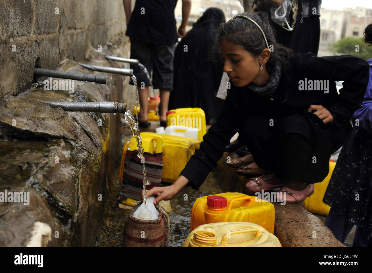 Sanaa, Yemen. 16th May, 2017. Yemeni children collect clean water from a charity water pump during a rain as they face clean water shortage in Sanaa, Yemen on May 16, 2017. Contaminated water is a reason causing the cholera disease in Yemen. Credit: Mohammed Mohammed/Xinhua/Alamy Live News Stock Photo