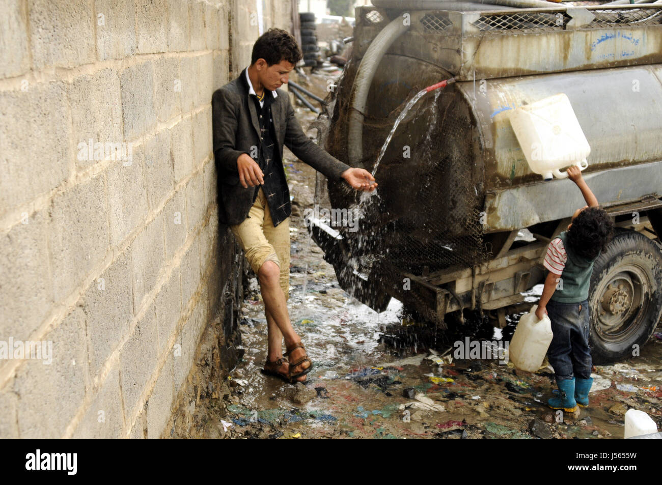 Sanaa, Yemen. 16th May, 2017. People wait to collect clean water from a charity water pump as a man fills his water tanker in Sanaa, Yemen on May 16, 2017. Contaminated water is a reason causing the cholera disease in Yemen. Credit: Mohammed Mohammed/Xinhua/Alamy Live News Stock Photo
