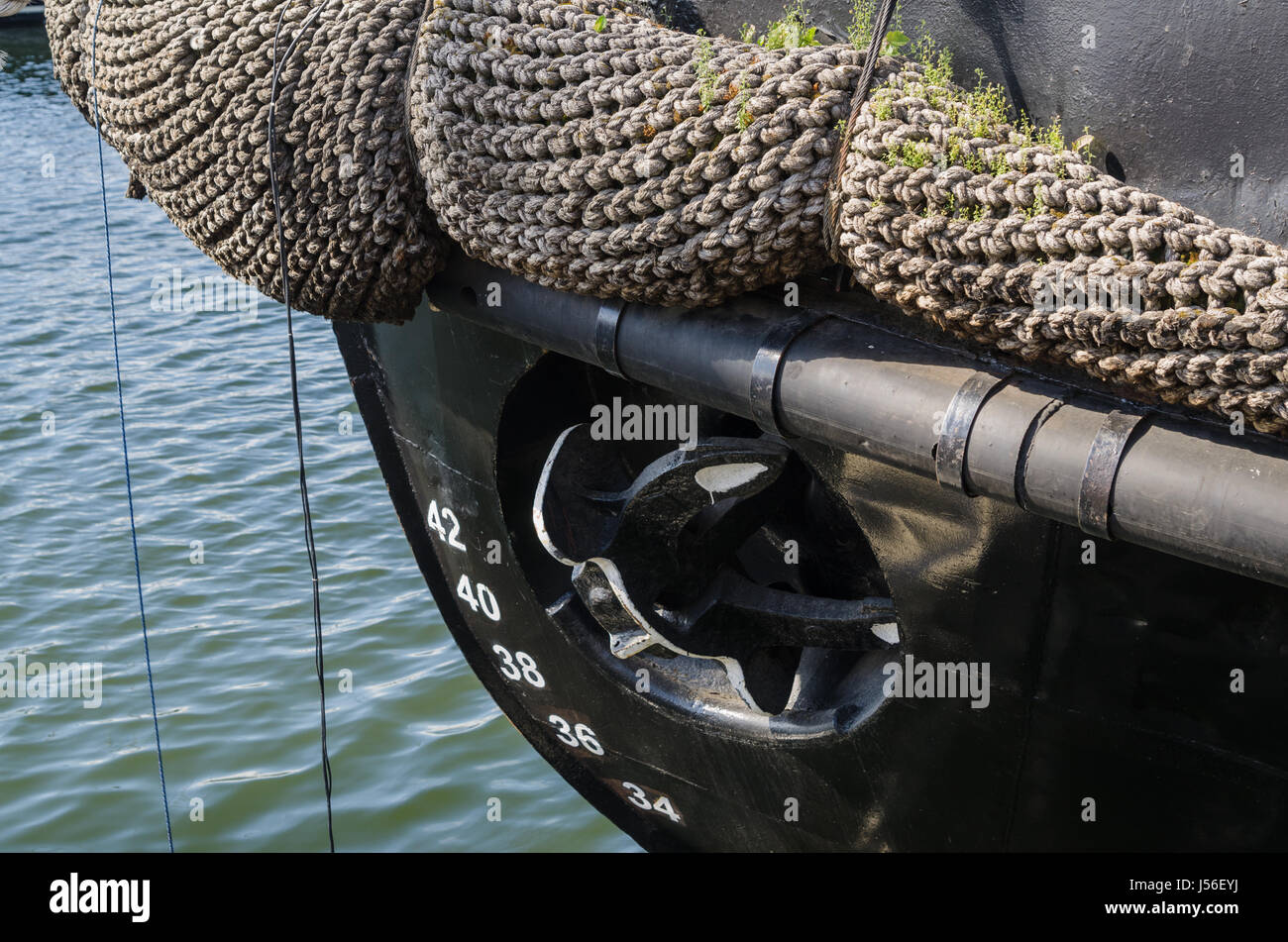 Old rusty anchor at a board of the ship Stock Photo