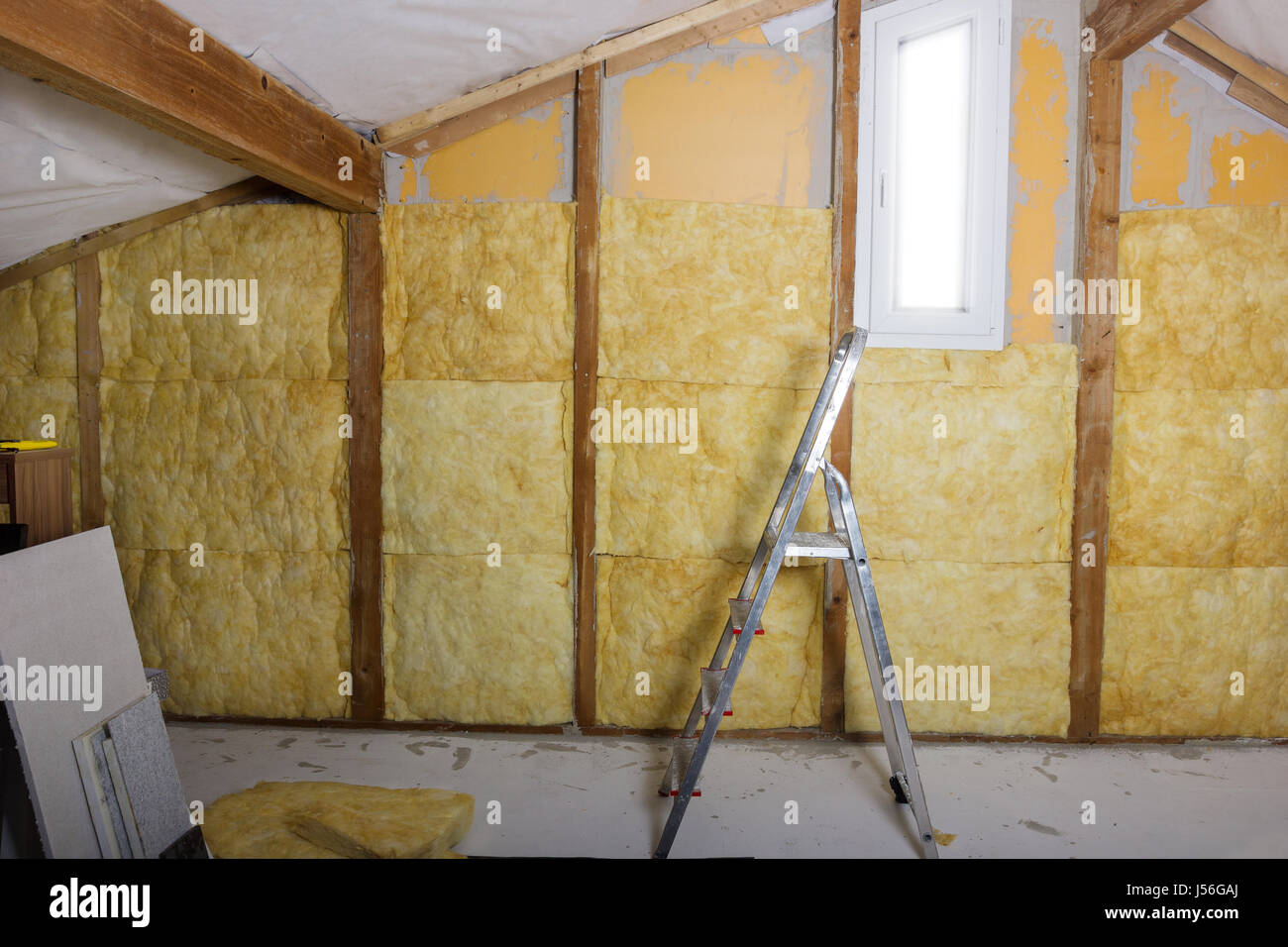 termal insulation installing at the attic with metallic ladder Stock Photo