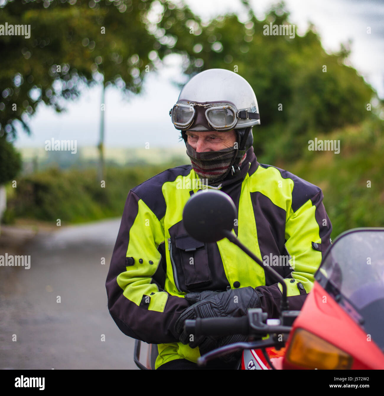 Old motorbiker wearing biking gear on his bike Stock Photo