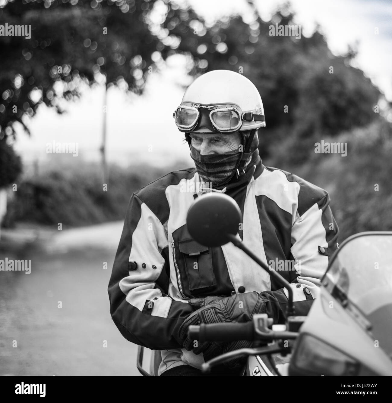 Old motorbiker wearing biking gear on his bike Stock Photo