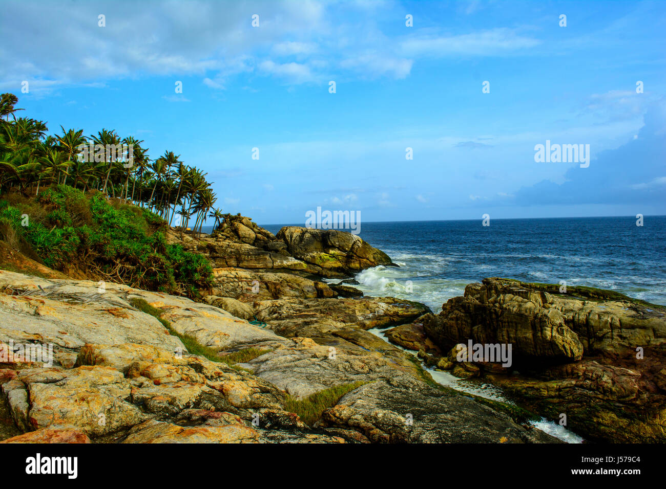 Waves washing ashore over rocks, Kerala India Stock Photo - Alamy