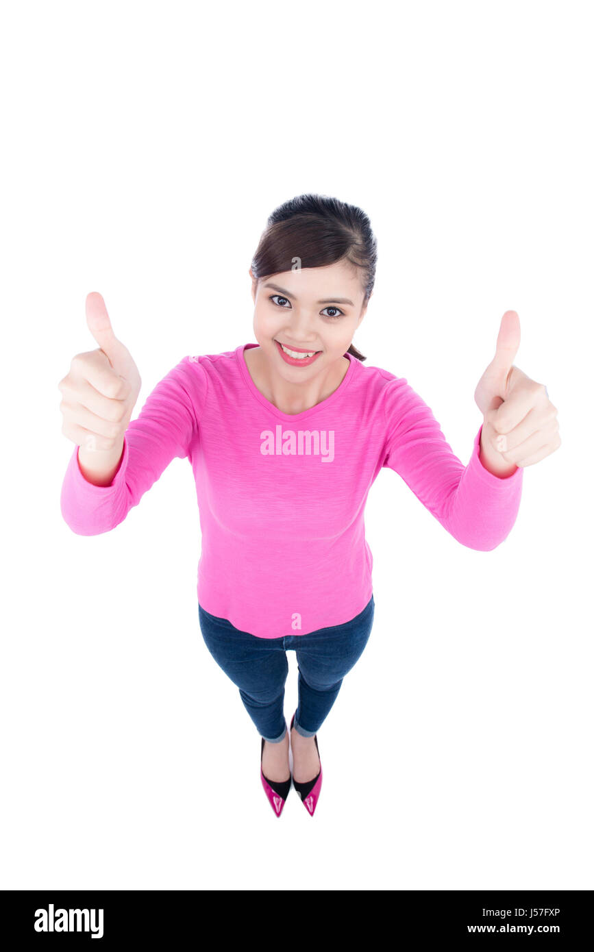 High angle perspective of a happy smiling young woman looking up at the camera giving a double thumbs up of success and approval isolated on white bac Stock Photo