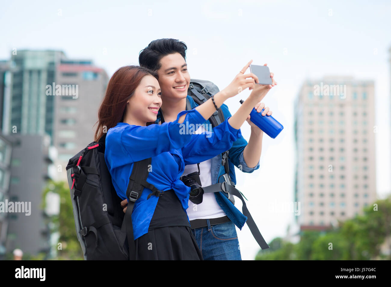 Happy tourists taking photo of themselves. summer holidays, travel, vacation, tourism and dating concept - couple taking photo picture with camera Stock Photo