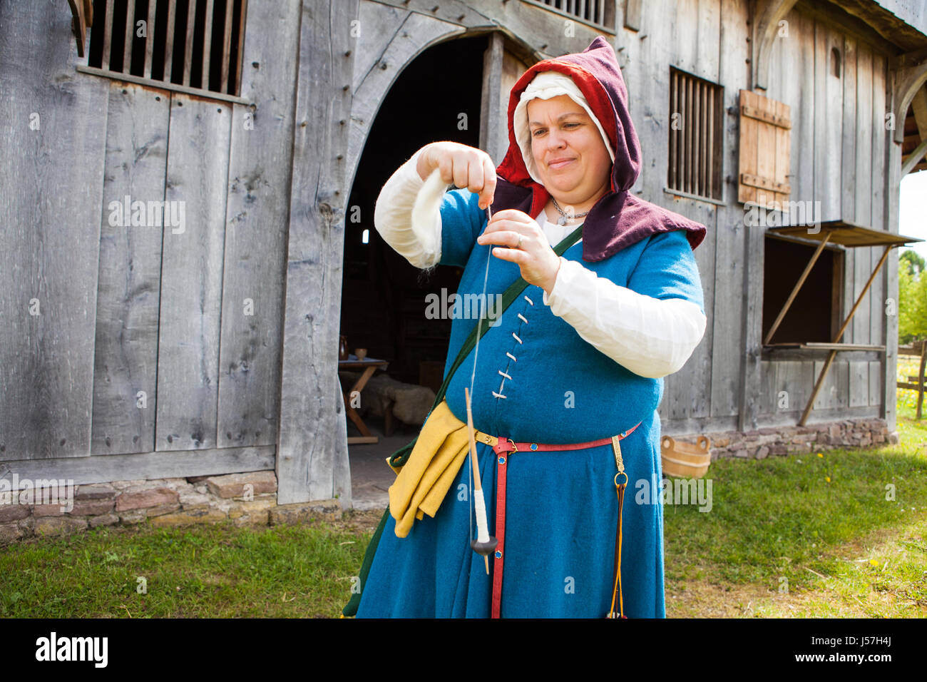 Spinning yarn by a member of a reenactment group, reconstructed medieval house, Nienover, Bodenfelde, Lower Saxony, Germany Stock Photo