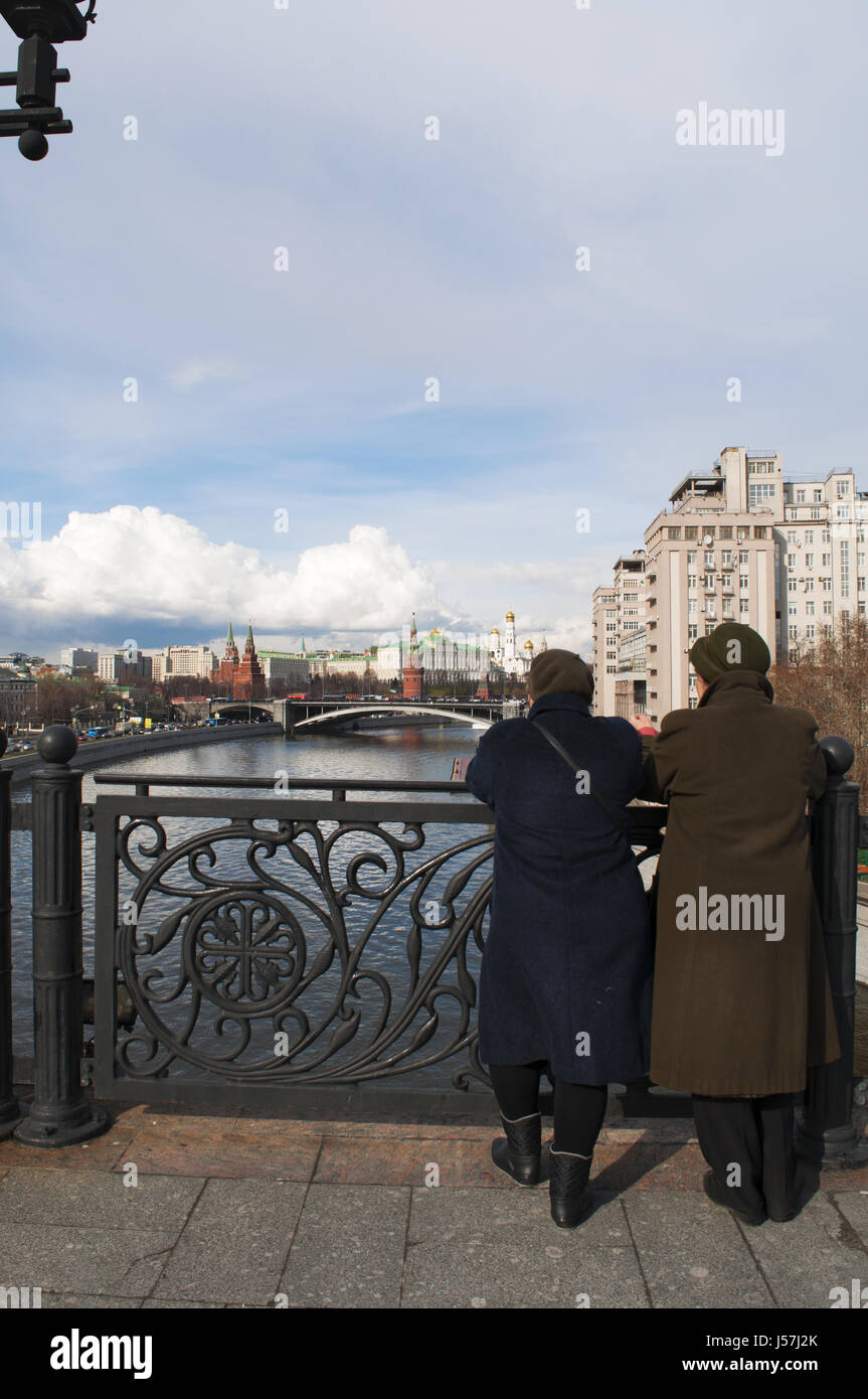 Moscow: old Russian women looking the skyline of Moscow with view of the fortified complex of the Kremlin from the Patriarch Bridge on Moskva River Stock Photo