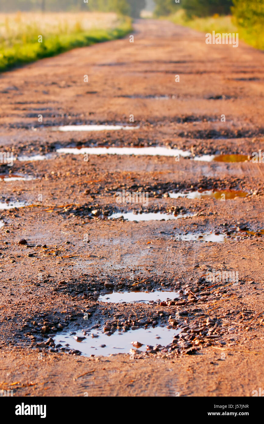 Local red clay road with wet holes surrounded by field and forest on  unfocused background. Poland, Swietokrzyskie Stock Photo - Alamy