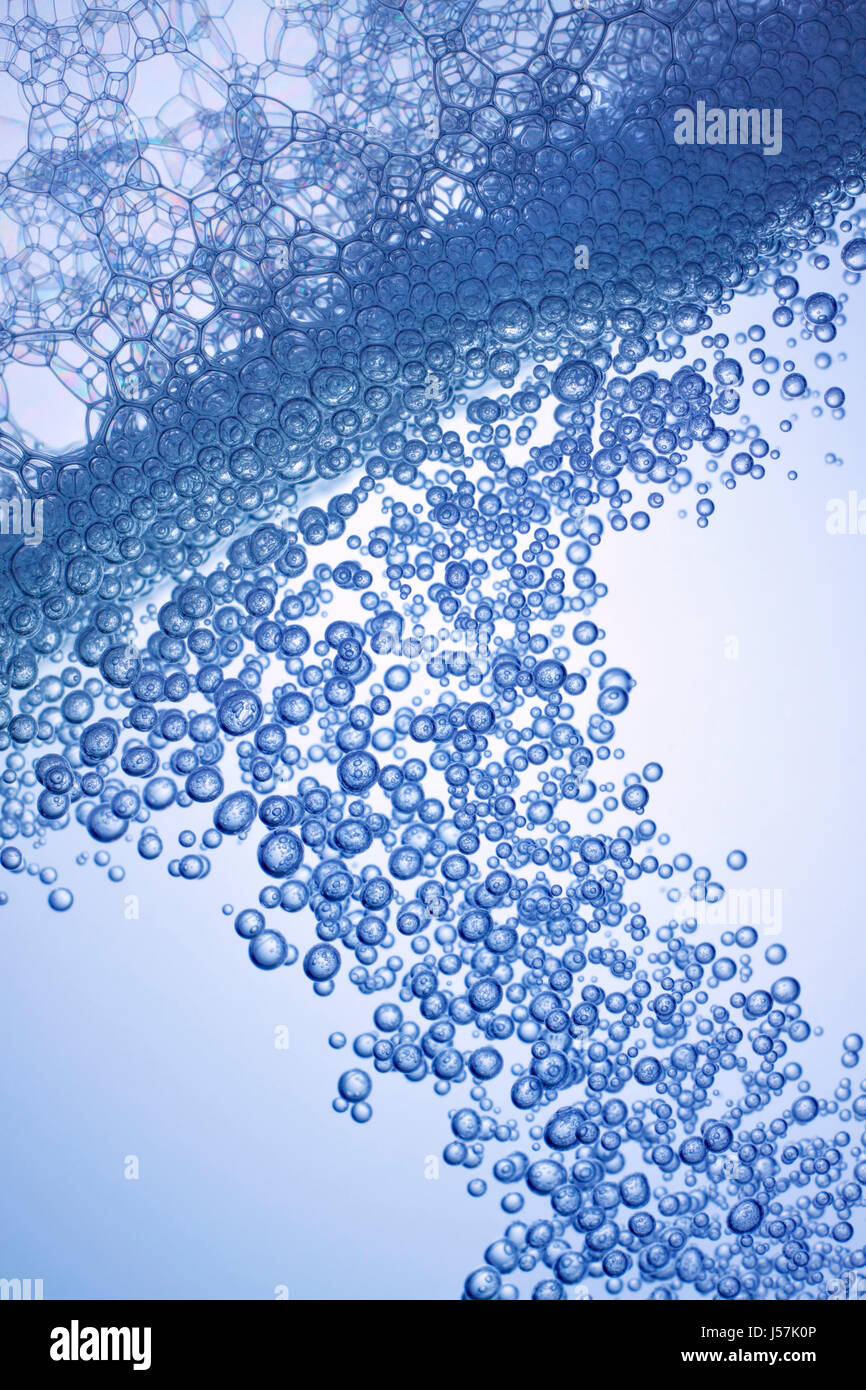 Waterline with dense air bubbles and soapy bubbles. Backlight, blue tint, oblique frame. Stock Photo