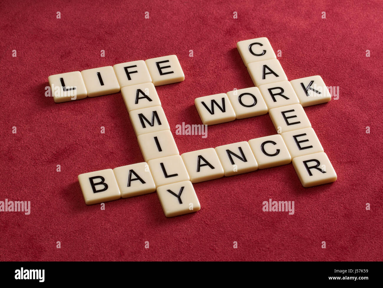 Crossword puzzle with words Life, Work and Balance. Life Management concept. Ivory tiles with capital letters on red velure. Stock Photo
