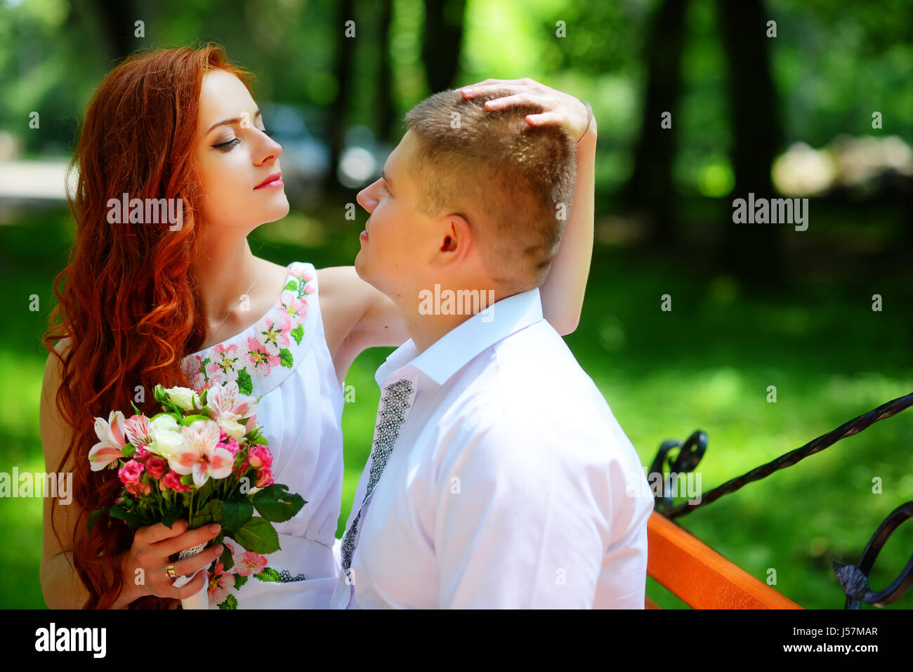 The bride and groom sit on a bench Stock Photo - Alamy