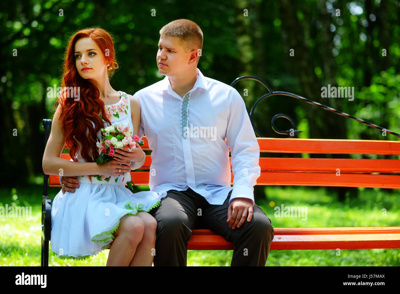 The bride and groom sit on a bench Stock Photo - Alamy