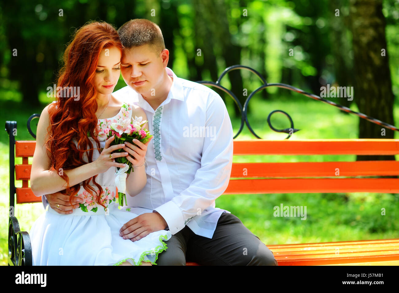 The bride and groom sit on a bench Stock Photo - Alamy