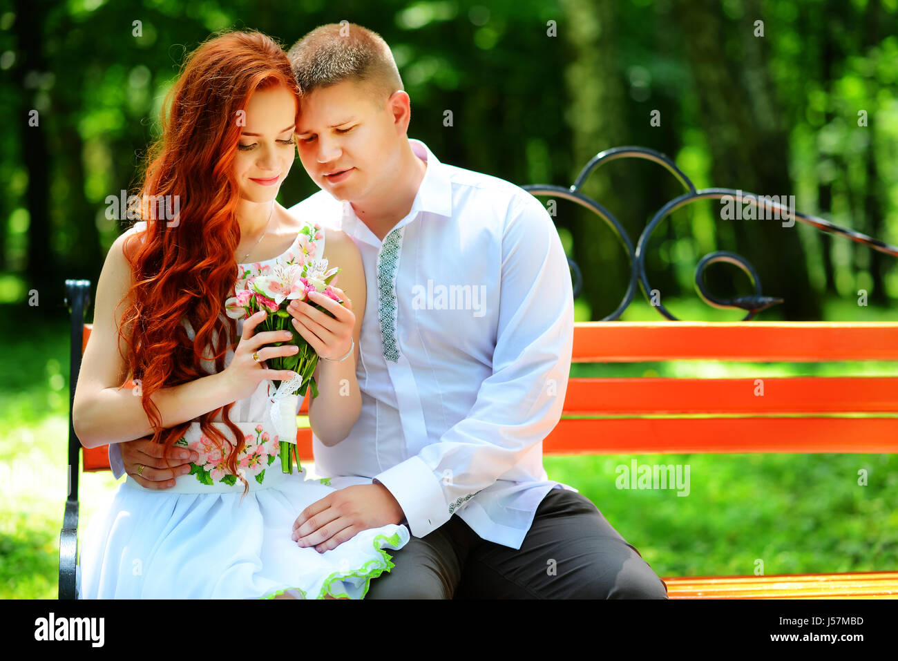 The bride and groom sit on a bench Stock Photo - Alamy