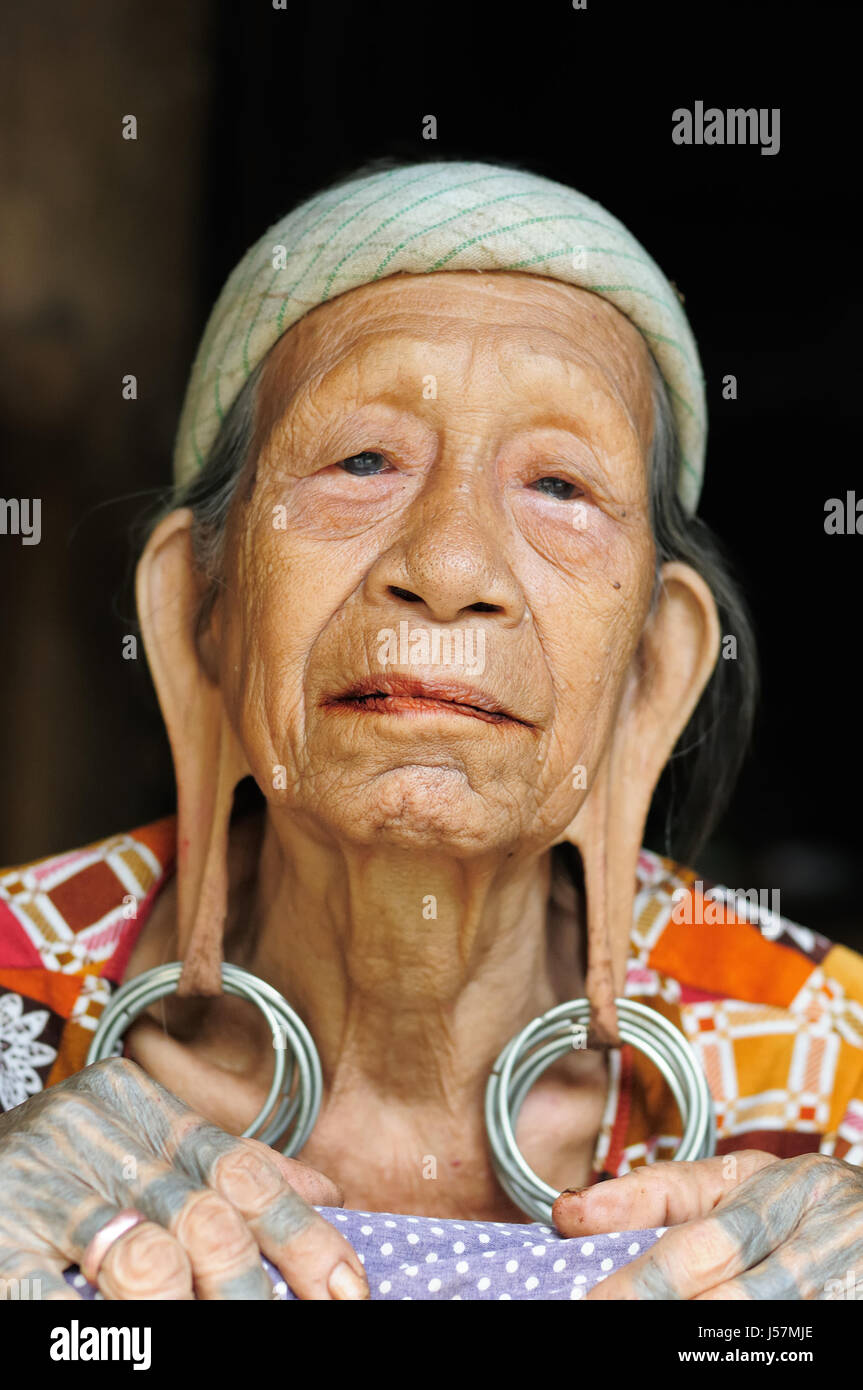 LONG BAGUN, BORNEO, INDONESIA - 10 JULY 2011: The older Dayak women with traditional long earlobes and tattoo from Borneo Stock Photo