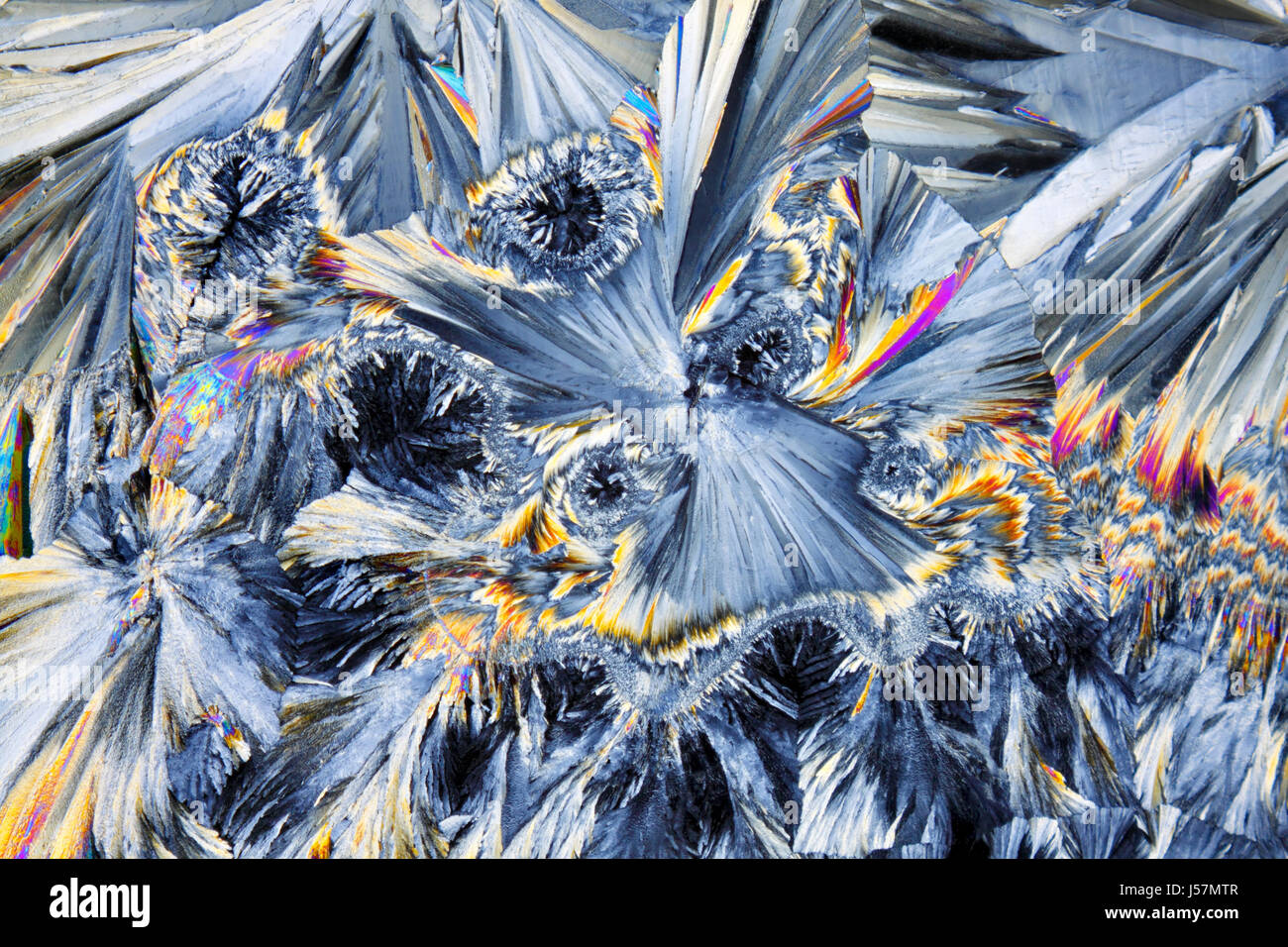 Microscopic view of colorful sucrose crystals. Recrystallized table sugar. Polarized light, crossed polarizers. Stock Photo