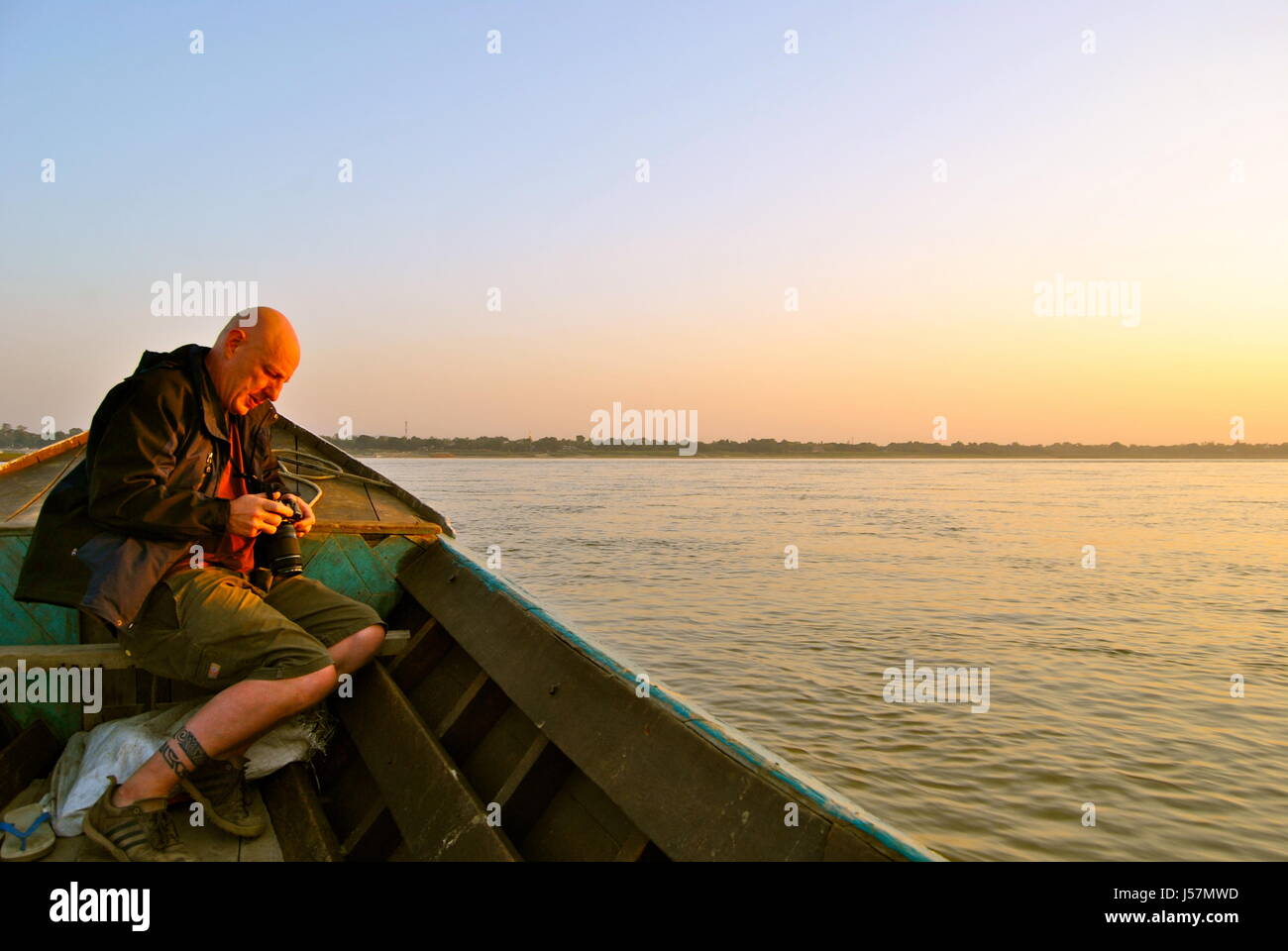 Man taking photos of a sunset on the Irrawaddy River, Bagan, Myanmar Stock Photo