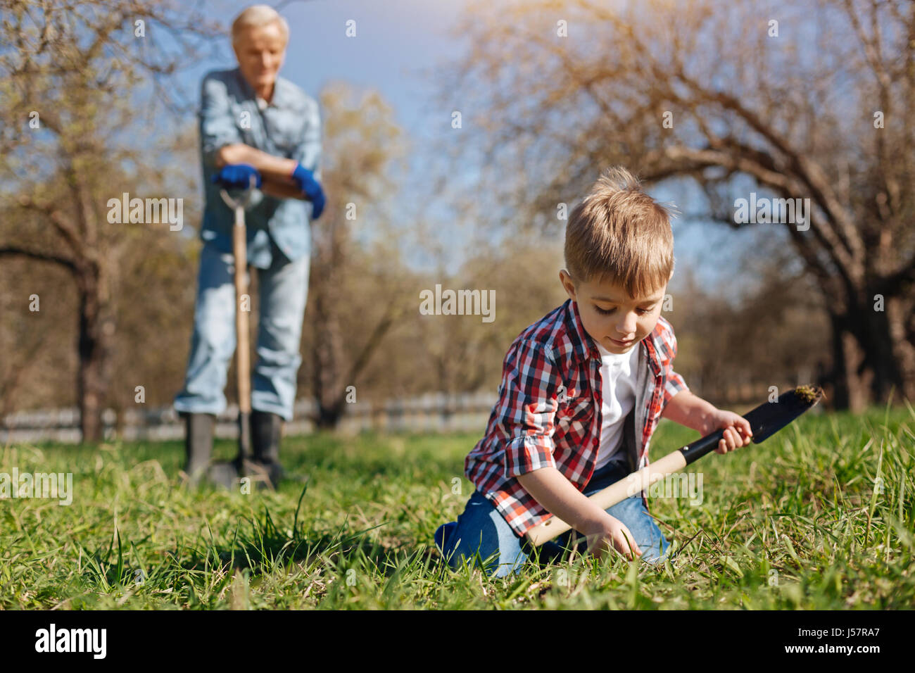 Little helper working in family garden Stock Photo - Alamy