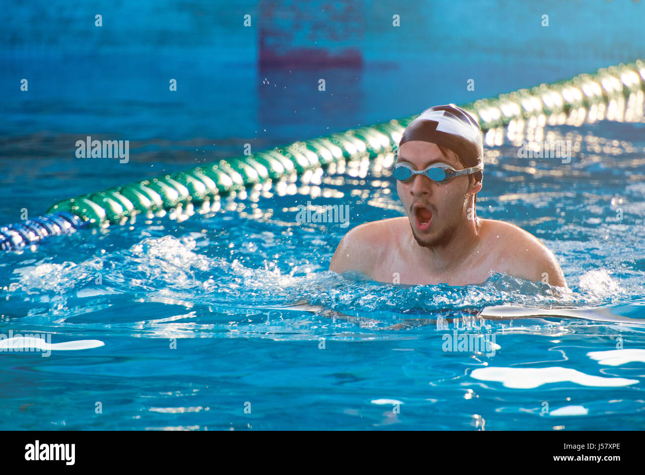 Man swim in pool lane on sunny day light. Man doing swimming sport Stock Photo