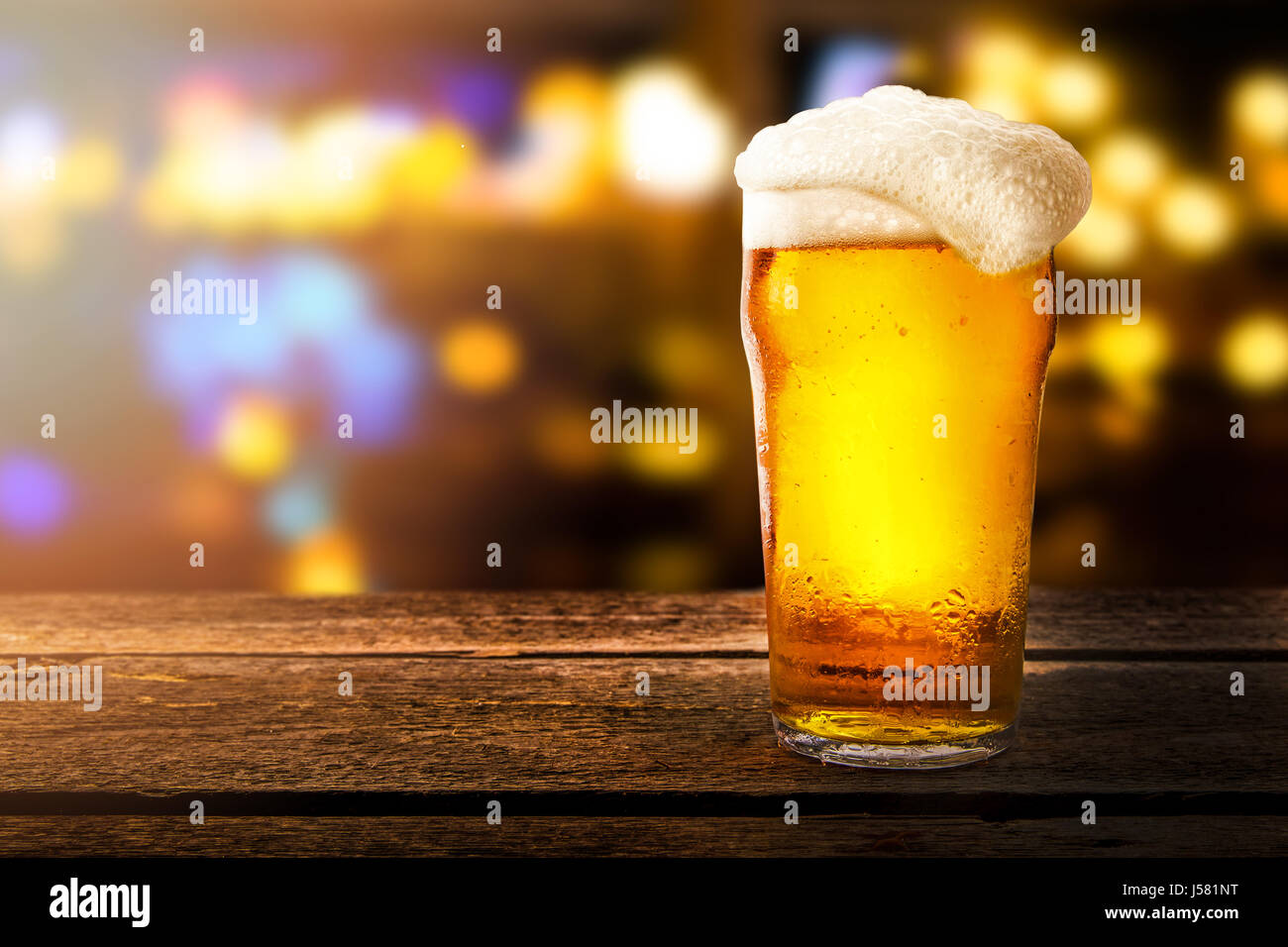 glass of beer on a table in a bar on blurred bokeh background Stock Photo