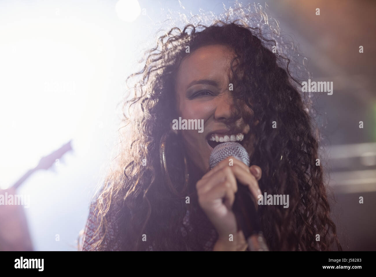Young female singer performing during music festival in nightclub Stock