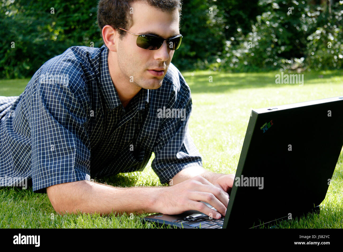 laptop notebook computers computer PC paper academic work garden green snug lie Stock Photo