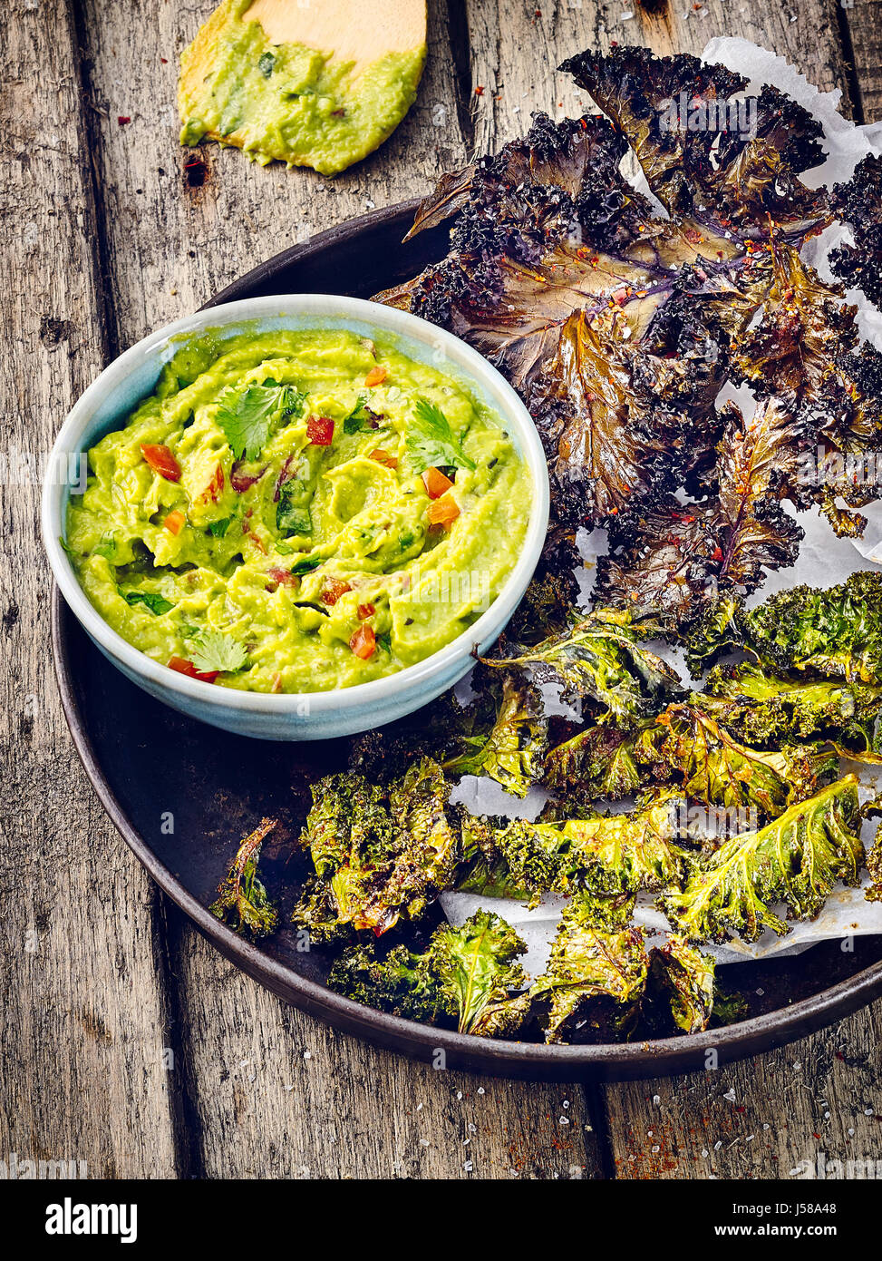 Two sorts of kale chips with guacamole Stock Photo