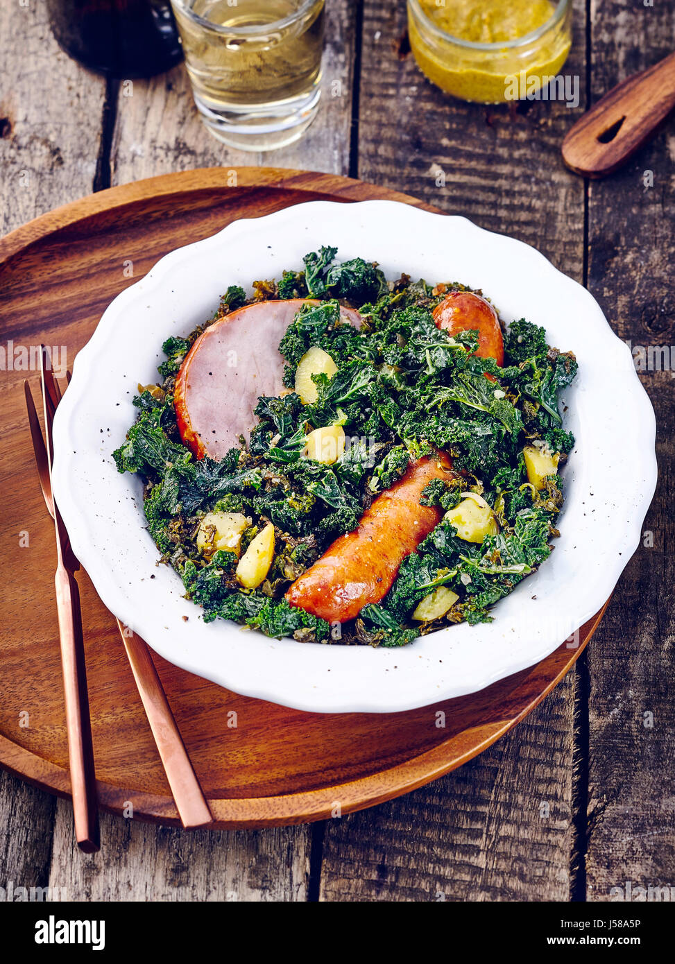 Kale with cabbage sausage and gammon steak Stock Photo