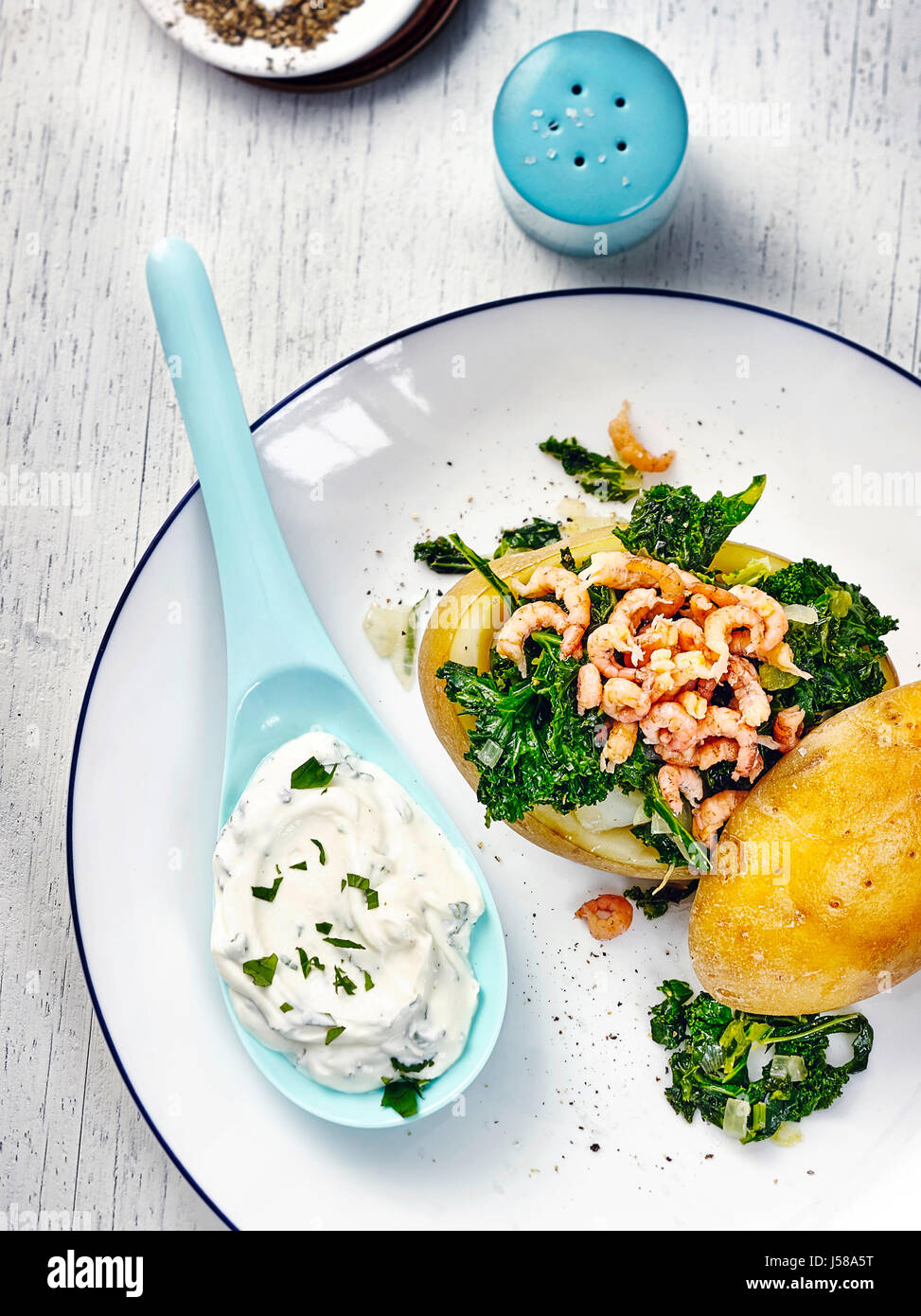 Baked potato with kale and shrimps Stock Photo