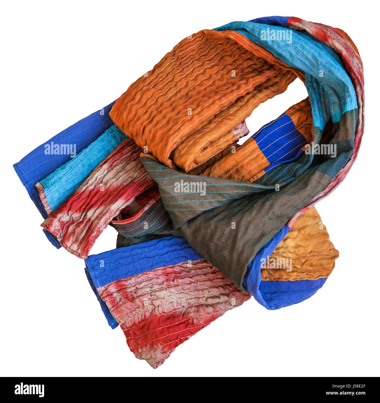 folded stitched patchwork scarf from batik and painted silk fabric pieces isolated on white background Stock Photo