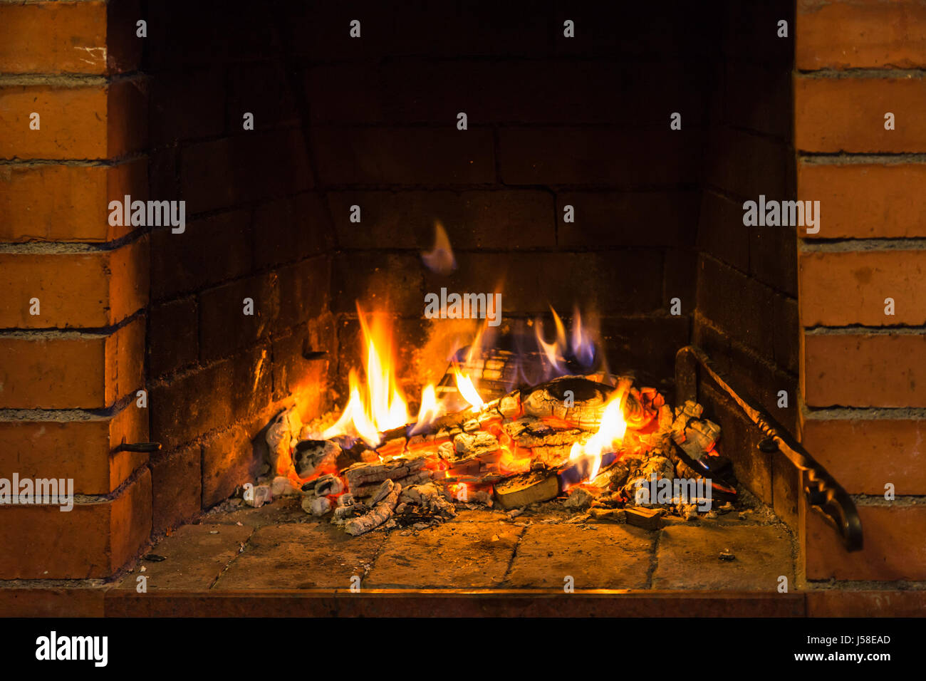 fire on burnt woods in fireplace in country cottage Stock Photo