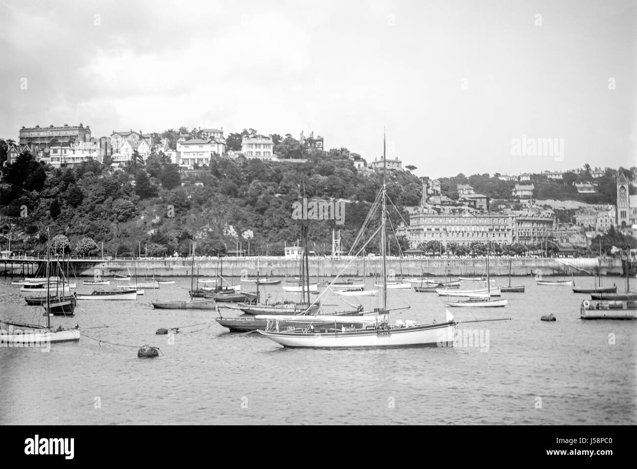 Torquay, Devon, seafront with boats anchored in the bay viewed from the sea. Photographed in 1920. Restored from a high resolution scan taken from the original negative. Stock Photo