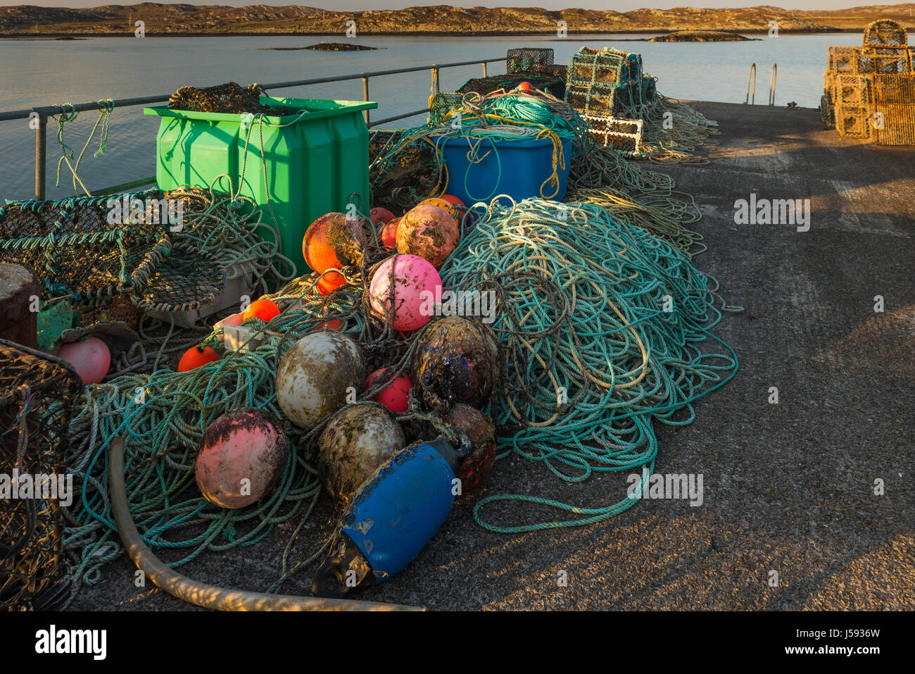 The parafhernalia of the fishing industry on Arinagour Pier The Isle of Coll Scotland Stock Photo