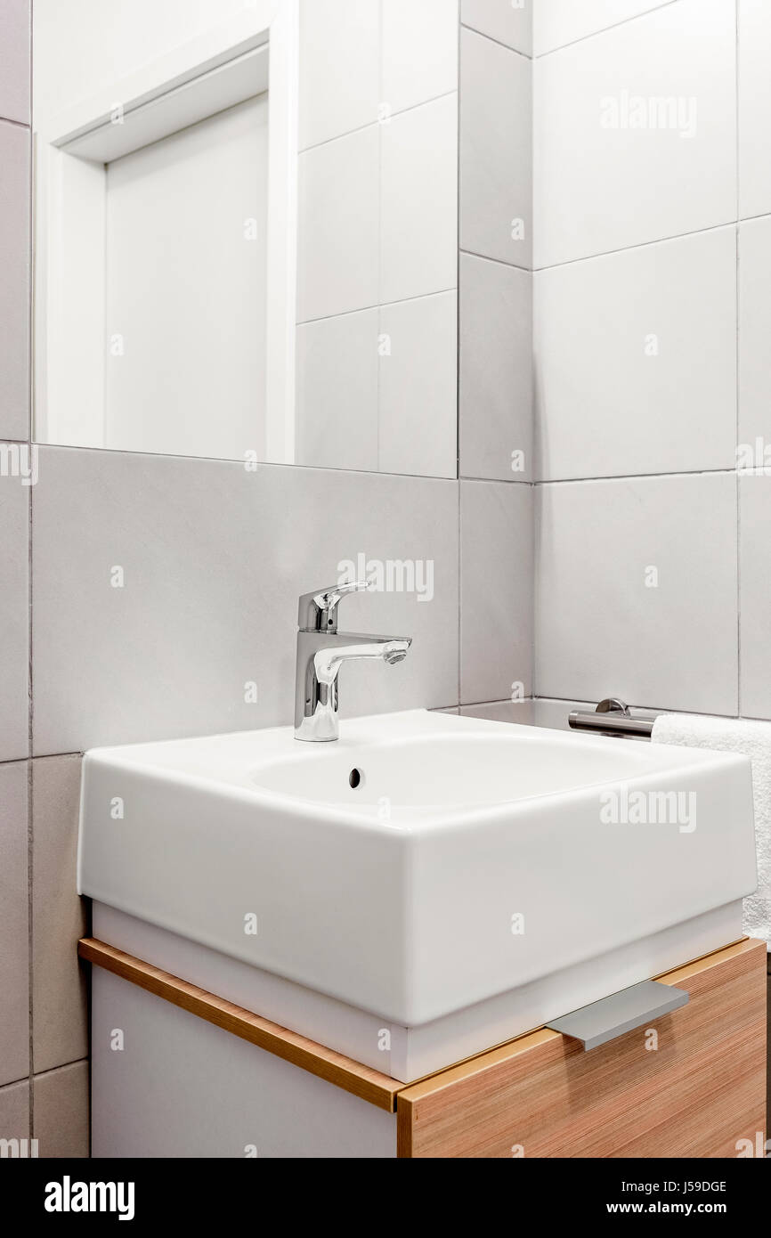 Modern And Ceramic Washbasin On Wooden Vanity Cabinet In Bathroom