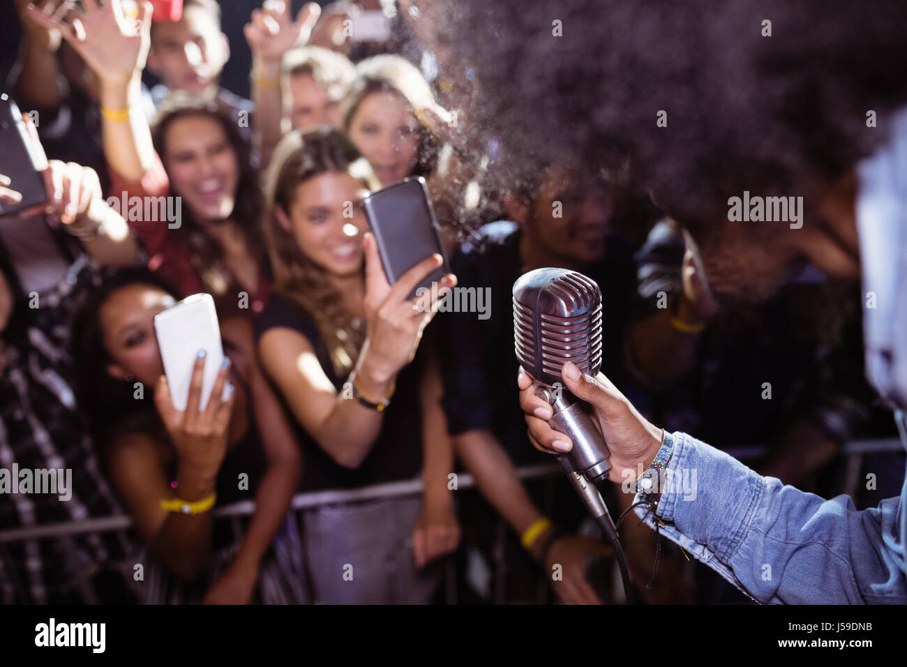 Playing With Fans Fans photographing singer performing at nightclub during music festival ...