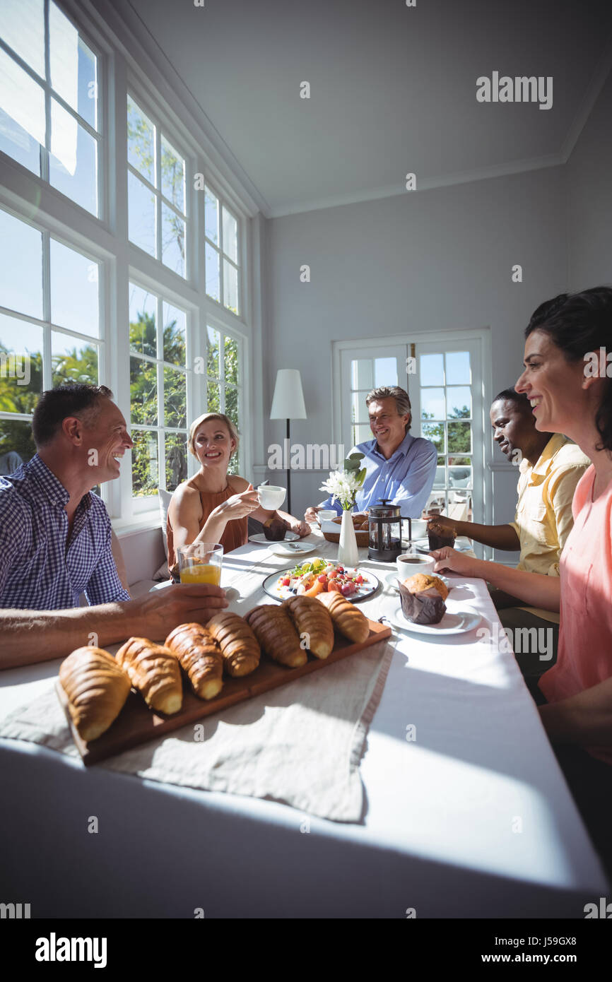 Group of friends interacting while having breakfast in restaurant Stock ...