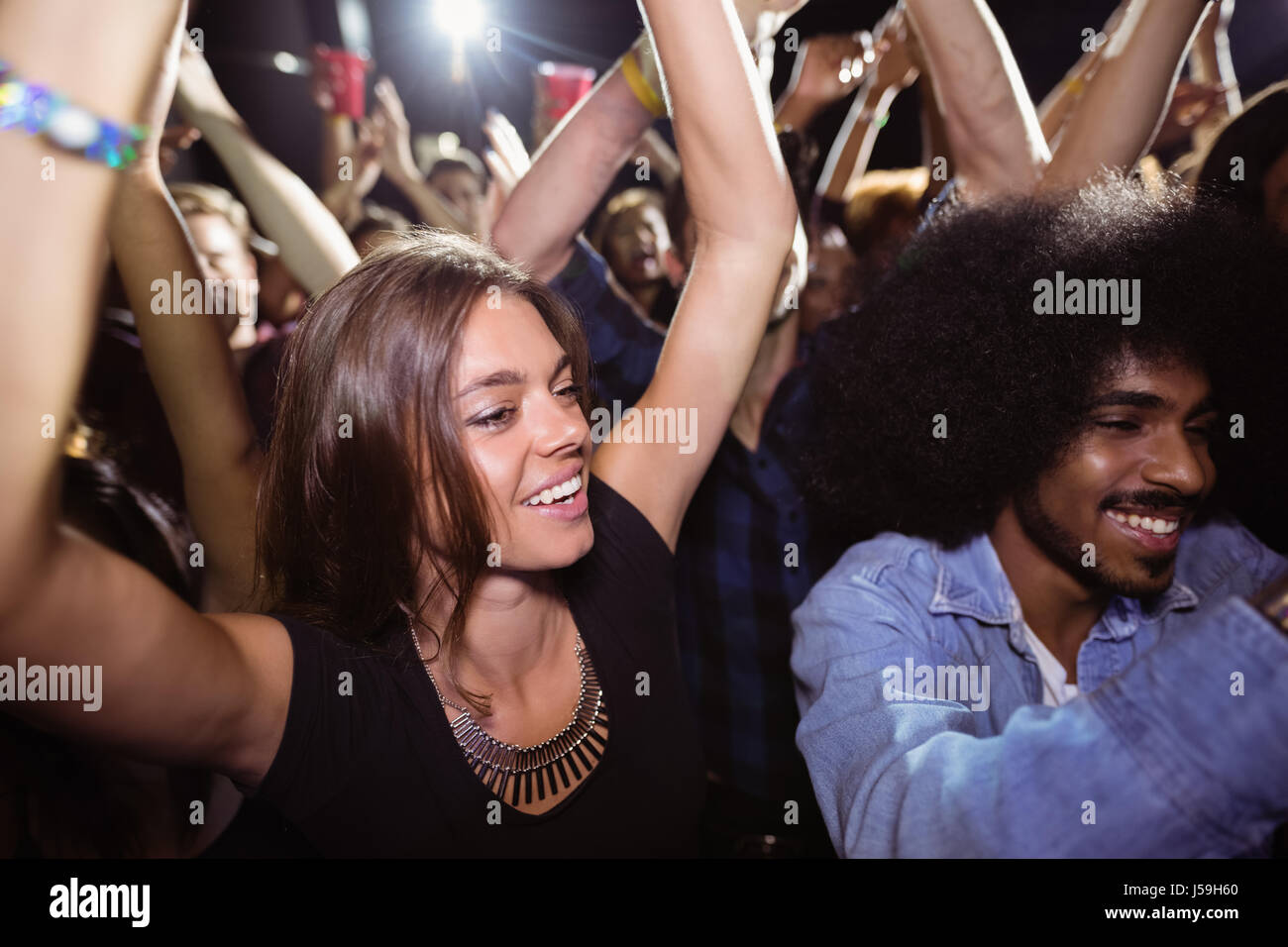 Friends dancing at nightclub during music festival Stock Photo