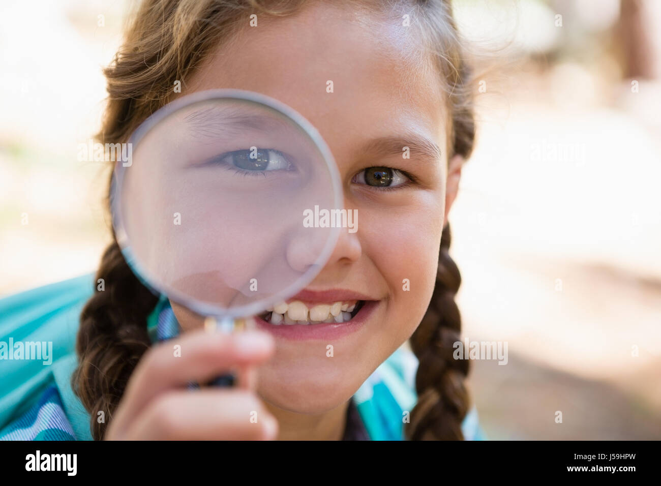 Smiling girl looking through magnifying glass in the forest Stock Photo ...