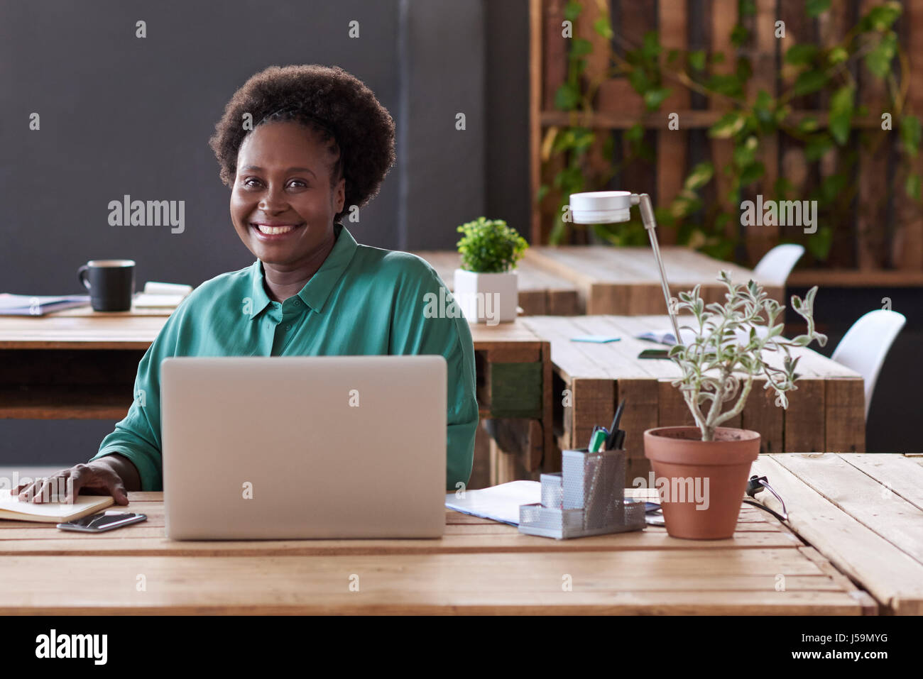 Smiling African businesswoman working at an office desk Stock Photo - Alamy