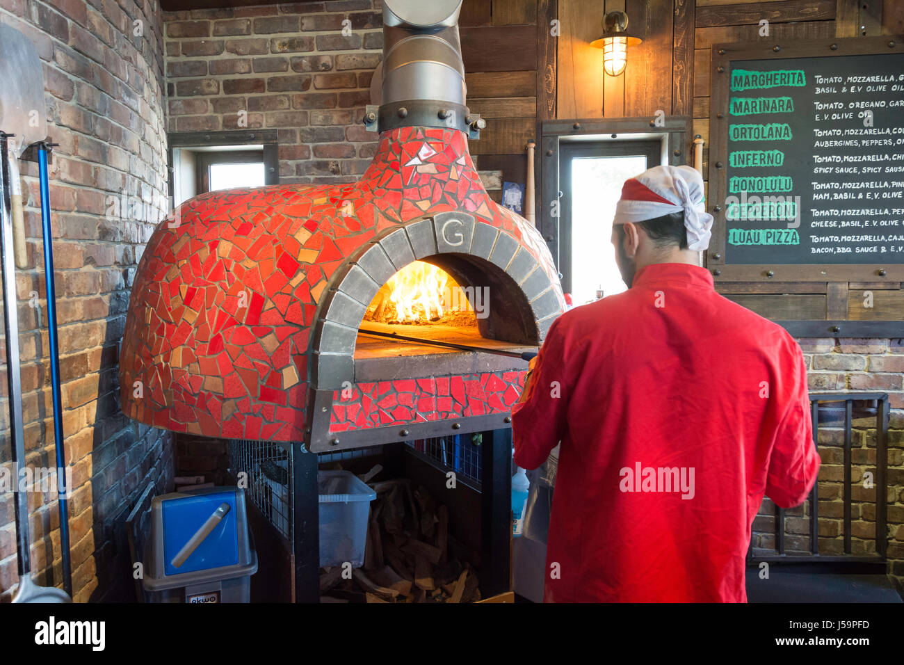 Man cooking pizza in pizza oven, Bournemouth, Dorset, England, United Kingdom Stock Photo