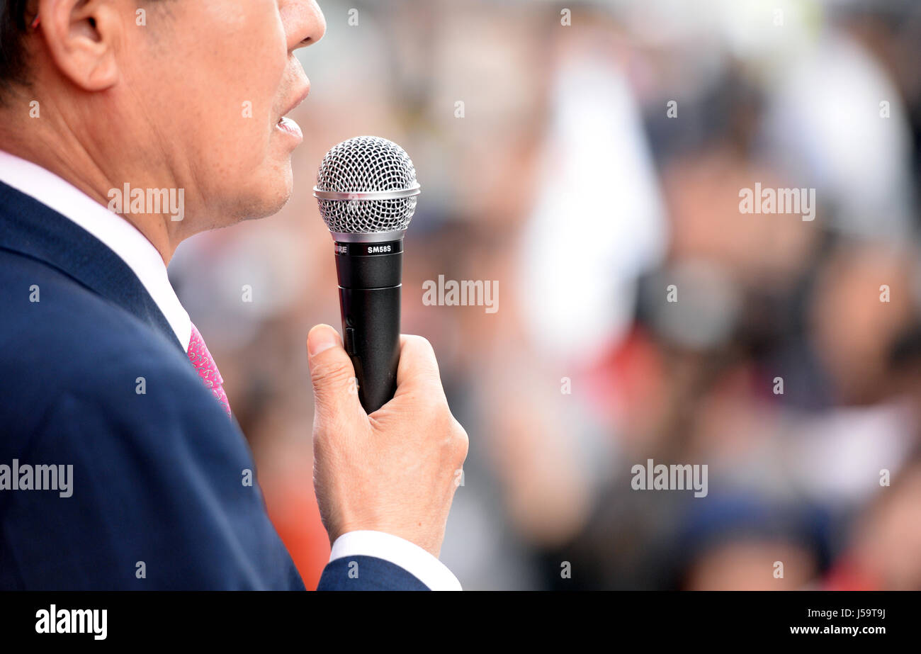 Closeup of a young formallydressed man giving a public speech in a