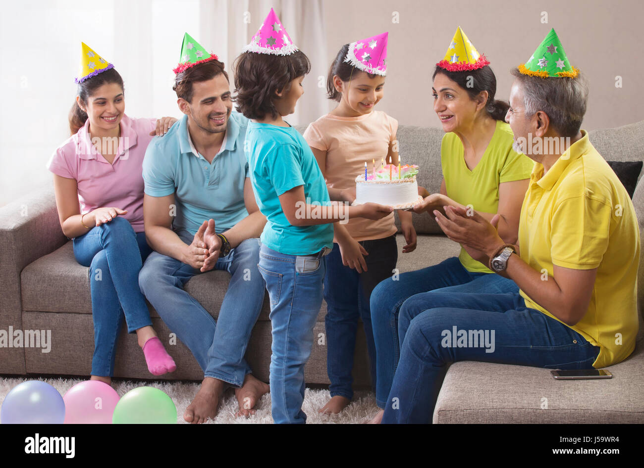 Family giving birthday party to grandmother Stock Photo