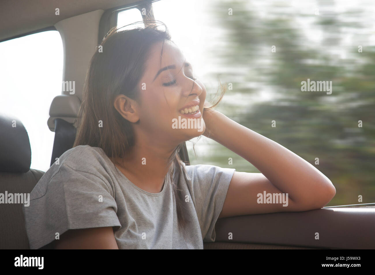 Beautiful women in car hair gets blown by the wind Stock Photo