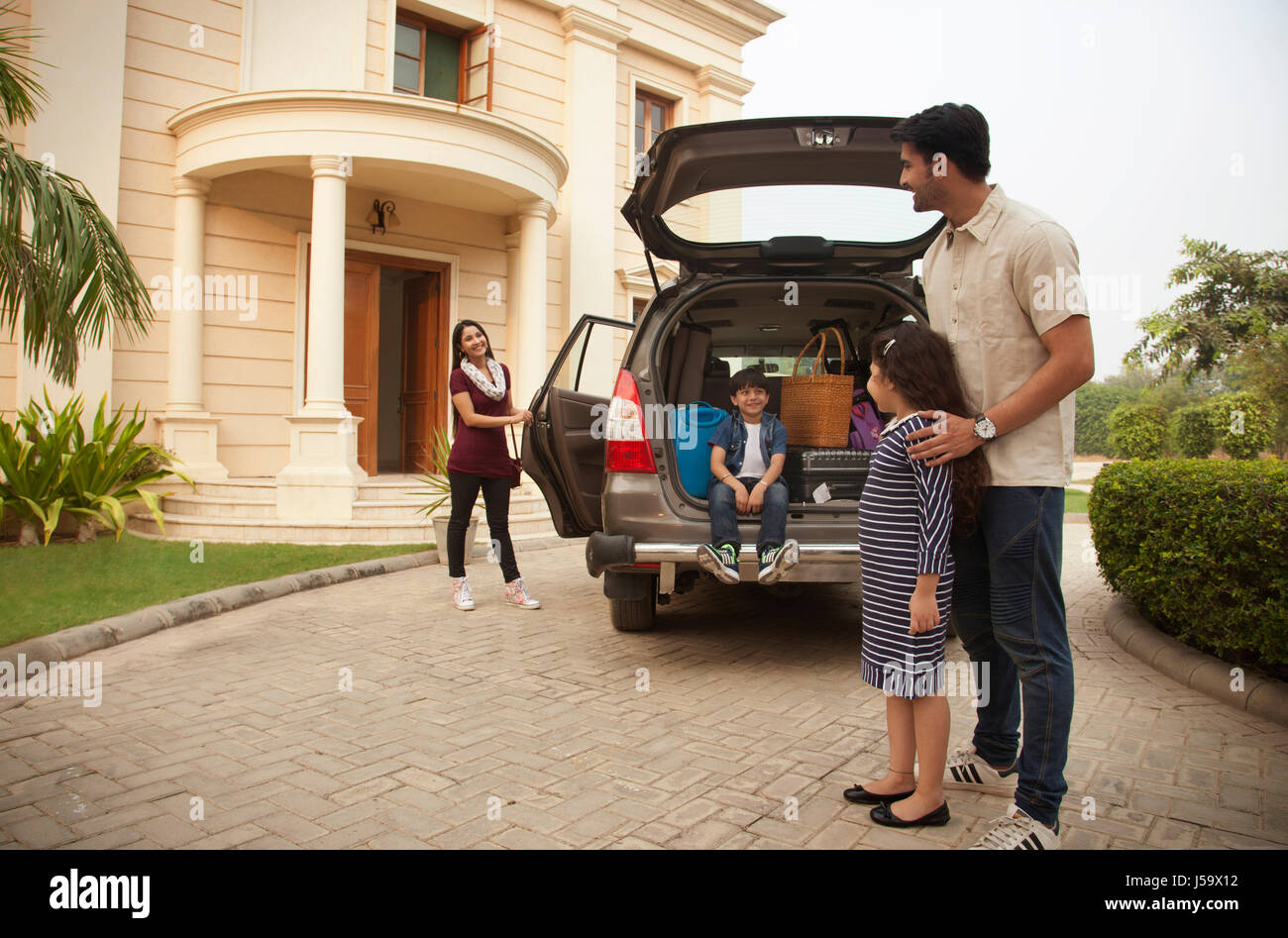 Family standing near car to go on vacation Stock Photo