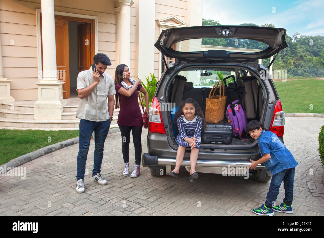 Family standing near car to go on vacation Stock Photo