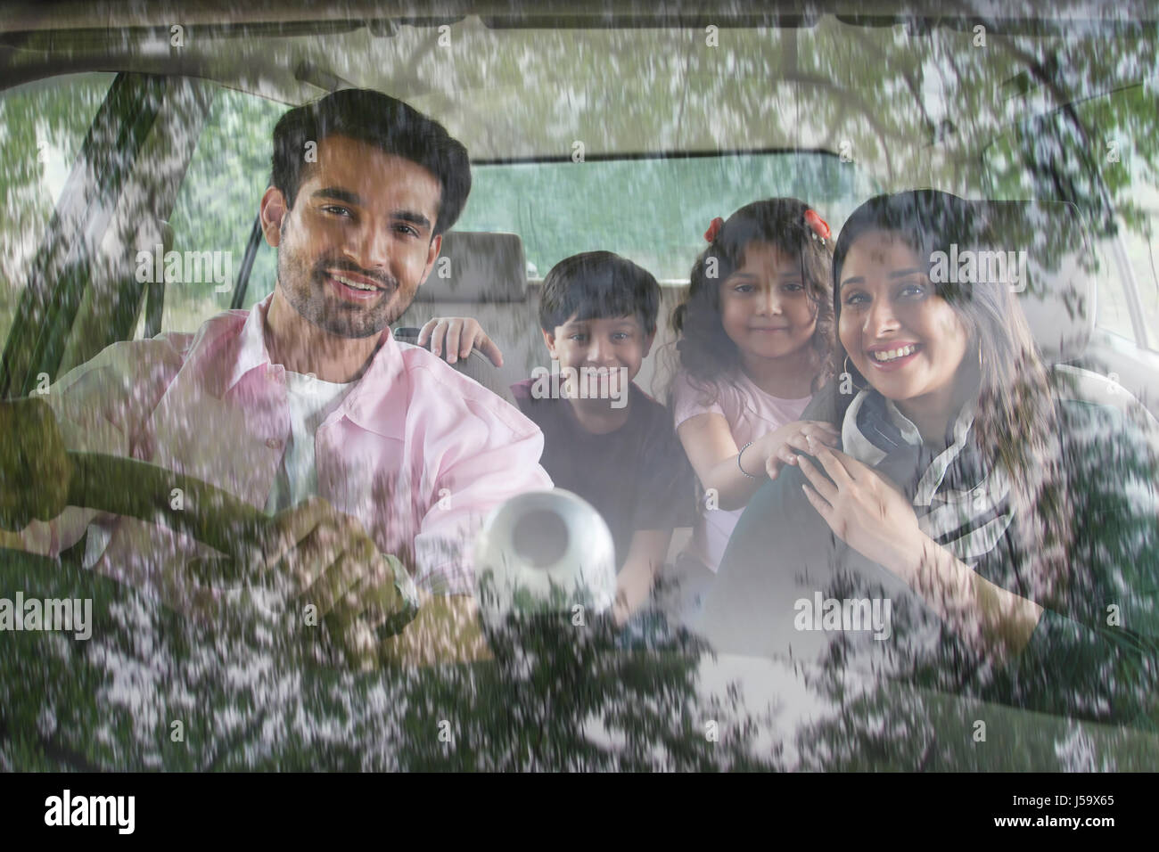 Happy family sitting inside car Stock Photo