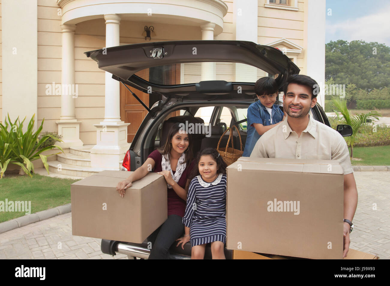 Family unpacking cardboard boxes from car Stock Photo